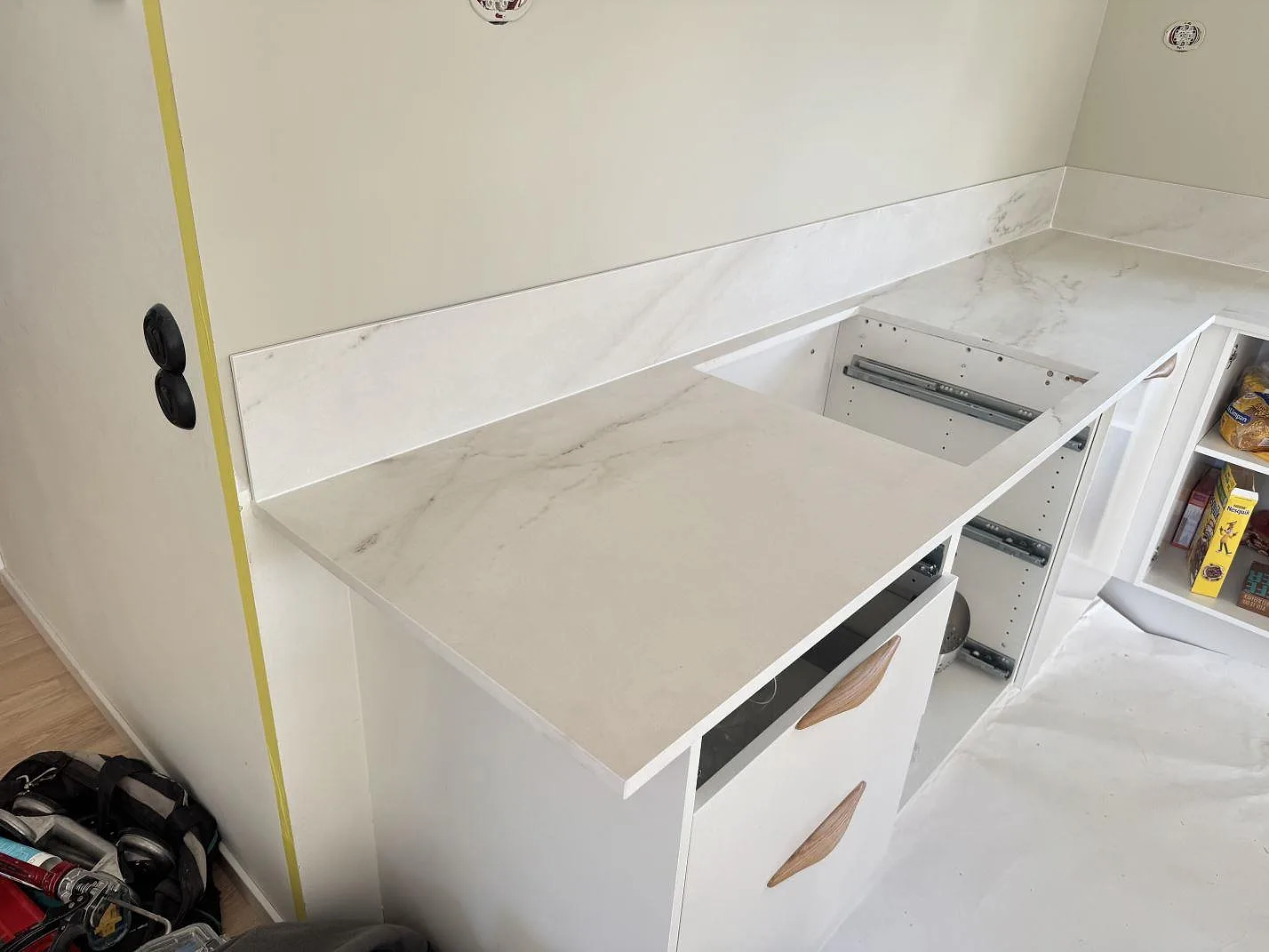 Köksbänkskiva i matt Dekton Rem (Velvet), keramik, med förberedd hällöppning och lågt stänkskydd under montering i Båstad.