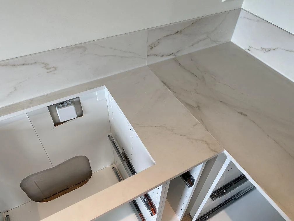 Ovanifrån av matt Dekton Rem Velvet bänkskiva med svaga grågula ådror på en köksbänk i Ellös.