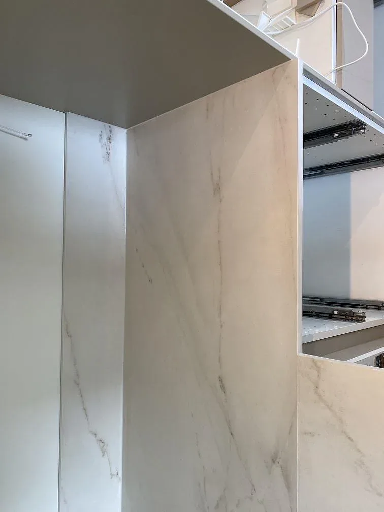 Köksbänkskiva i matt Dekton Rem Velvet med uppvikt stänkskydd längs väggen i ett kök i Ellös.