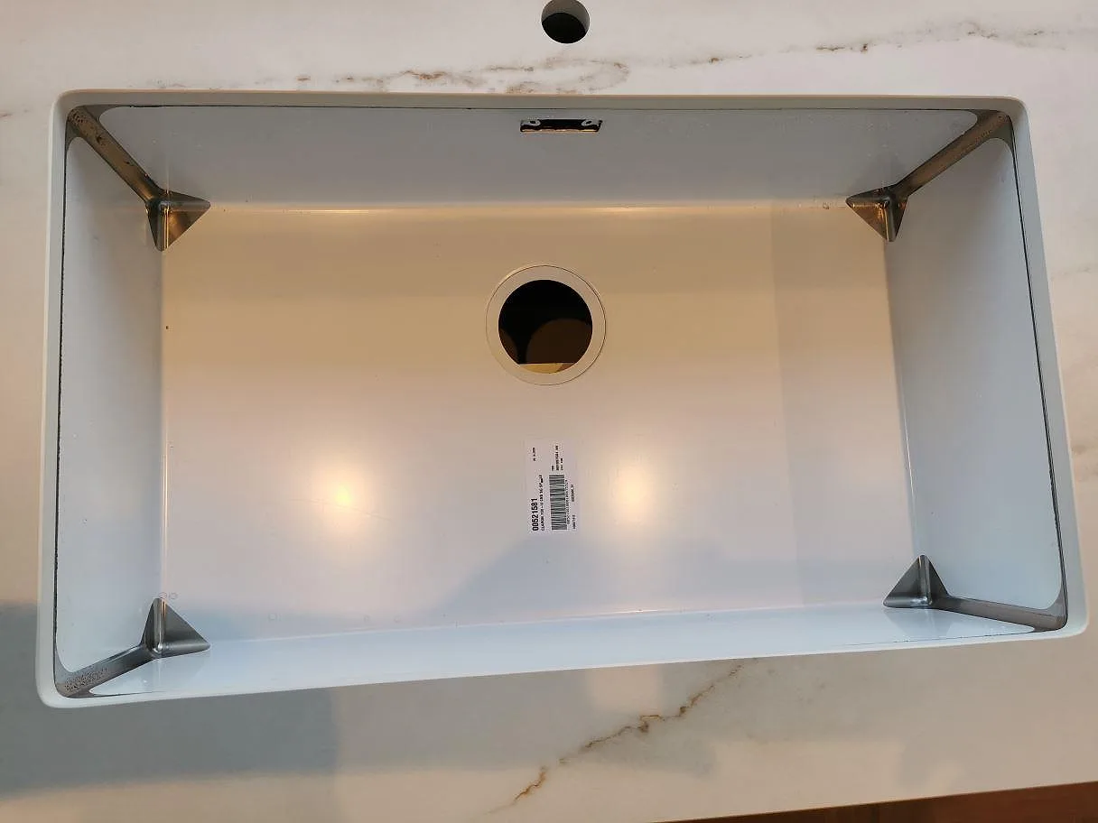 Underlimmad vit diskho infälld i köksbänkskiva av Dekton Rem (Velvet) i ett kök i Greve.