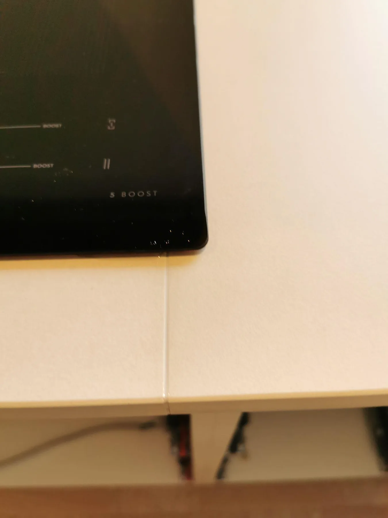 Induktionshäll monterad ovanpå köksbänkskiva av matt Dekton Rem (Velvet) i ett kök i Greve.