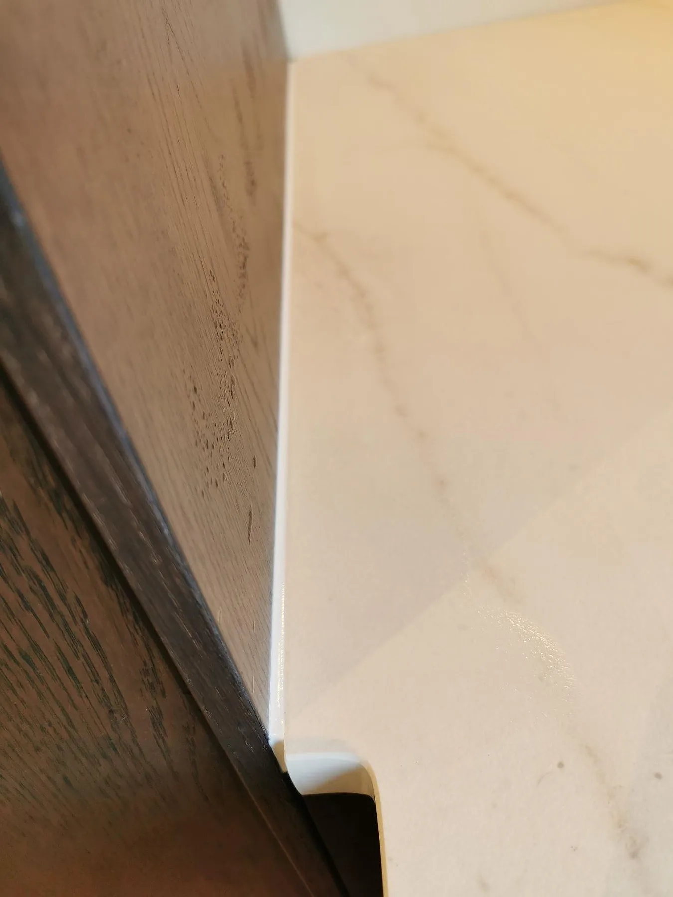 Kantprofil på 20 mm köksbänkskiva i matt Dekton Rem (Velvet) med diskret ådring i ett kök i Greve.