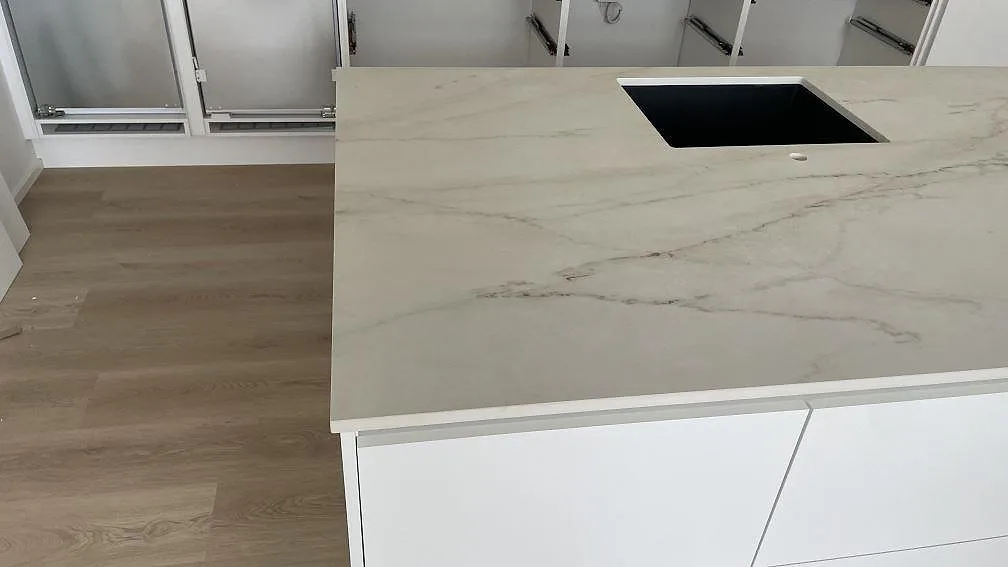 Närbild av matt Dekton Rem (Velvet) på köksö med diskhoöppning och mjuk grå ådring i Hvidovre.