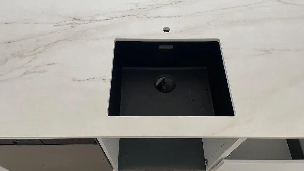 Matt Dekton Rem (Velvet) som köksbänkskiva med svart diskho och synlig ådring i ett kök i Hvidovre.