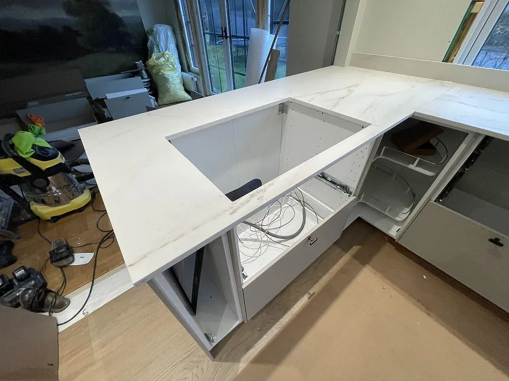 Närbild på halvö med köksbänkskiva i matt Dekton Rem (Velvet) och förberett hällurtag i Kristinehamn.