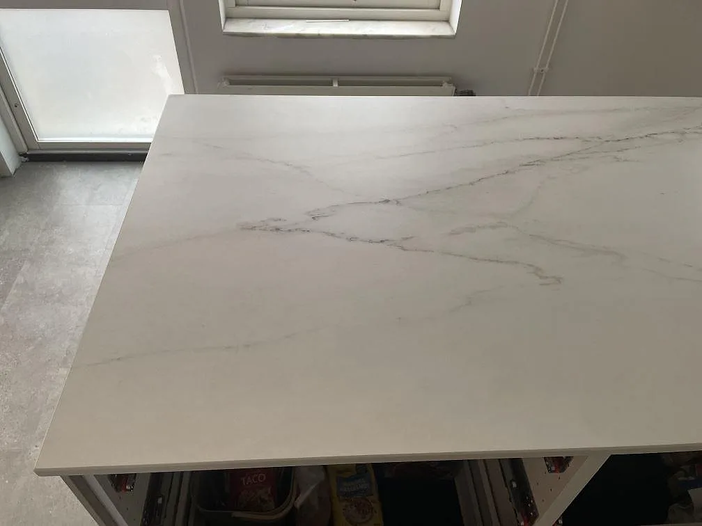 Närbild på den vita, marmorlika ådringen i en matt köksbänkskiva av Dekton Rem Velvet i ett kök i Malmö.