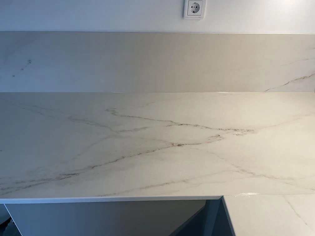 Köksbänkskiva i Dekton Rem Velvet med uppvikt stänkkant och tydlig taupe-ådring, matt yta, i ett kök i Malmö.