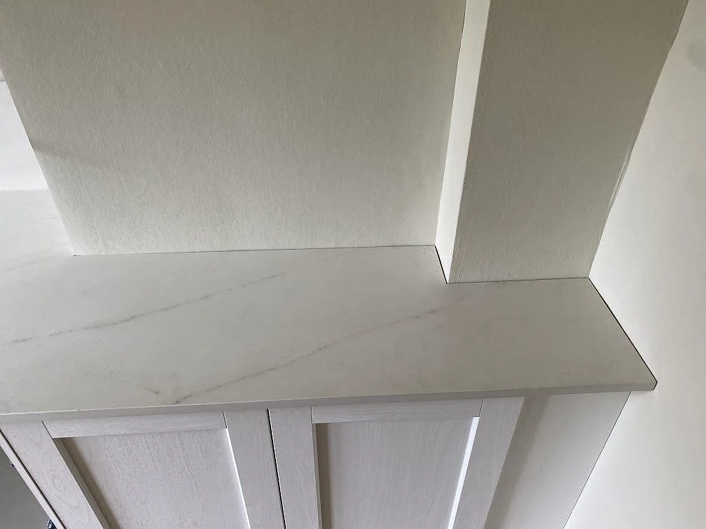 Hörn och avslut på en matt köksbänkskiva i Dekton Rem Velvet med 8 mm stänkskydd och vita skåpsidor i Malmö.