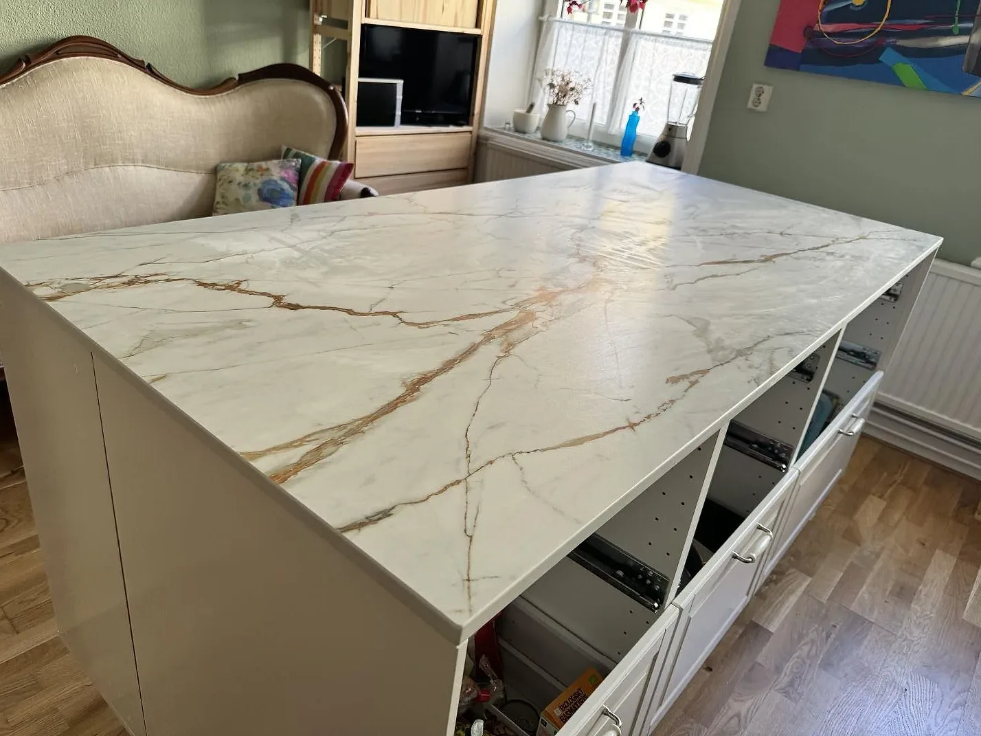 Närbild av köksö i matt Dekton Reverie där den vita keramiken visar guldbruna och grå ådringar i ett kök i Malmö.