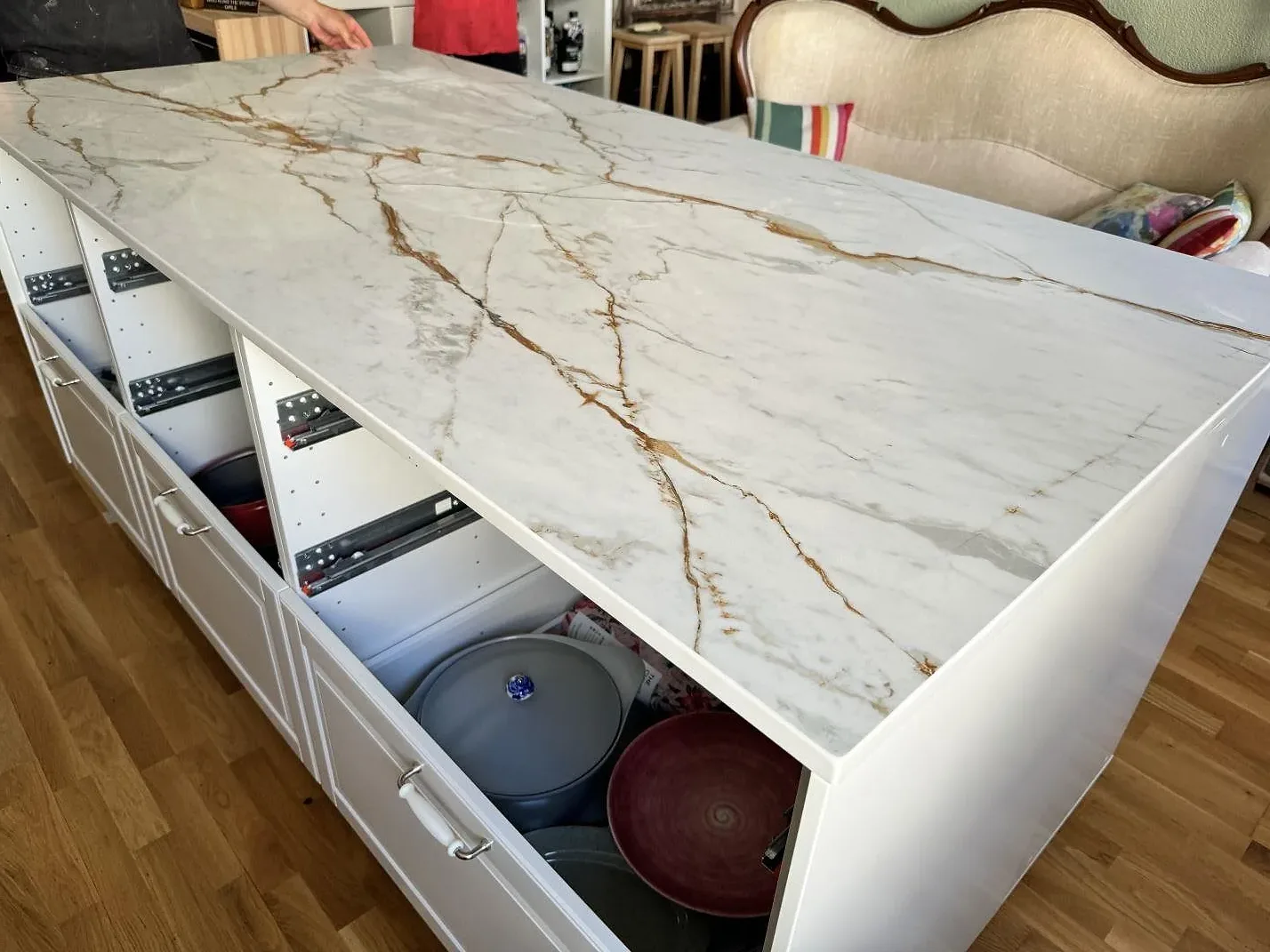 Köksbänkskiva i matt Dekton Reverie på köksö med öppna lådfronter och markerad veining under montering i Malmö.