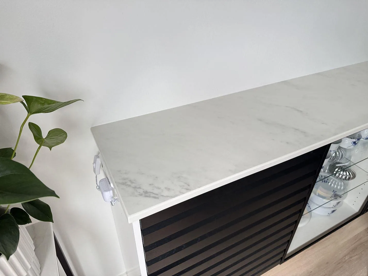 Möbelskiva i polerad Dekton Salina keramik med synlig ådring och växt intill i Ishøj.