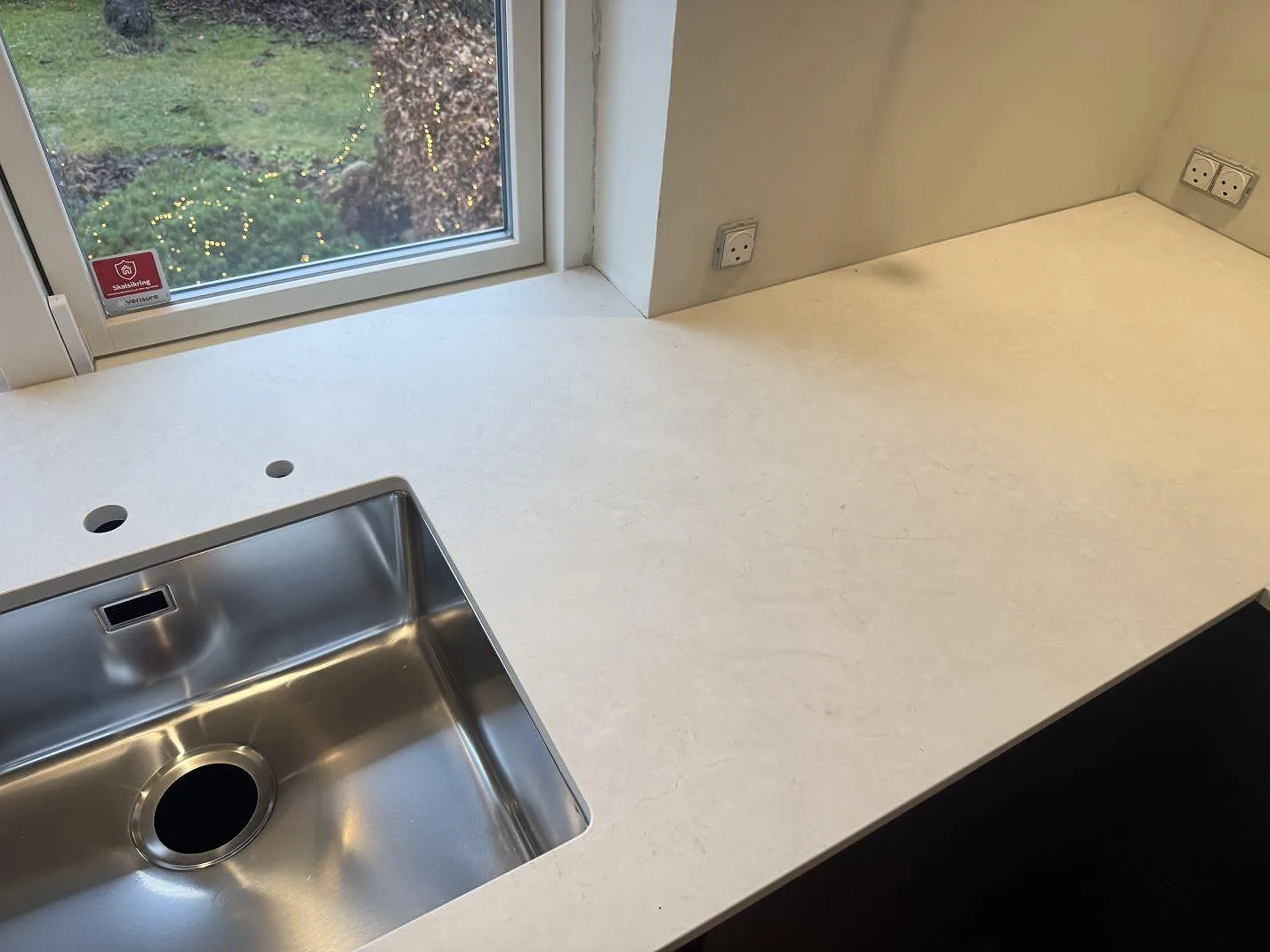 Ljus Dekton Sandik bänkskiva i matt keramik med rostfri diskho och sammanhängande hörnyta i Kgs Lyngby.