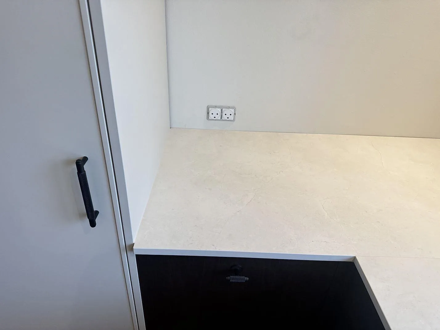 Rak del av köksbänkskiva i matt Dekton Sandik monterad mot vägg och högskåp i Kgs Lyngby.