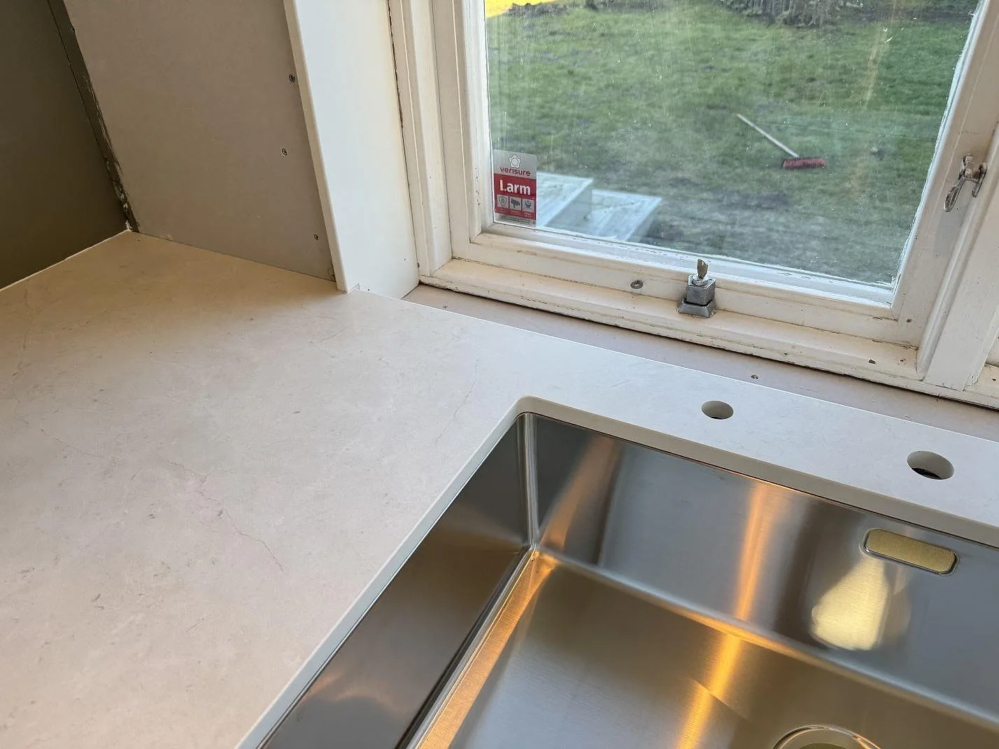 Matt Dekton Sandik som köksbänkskiva med diskho vid fönster och ljus ådring i ett kök i Malmö.