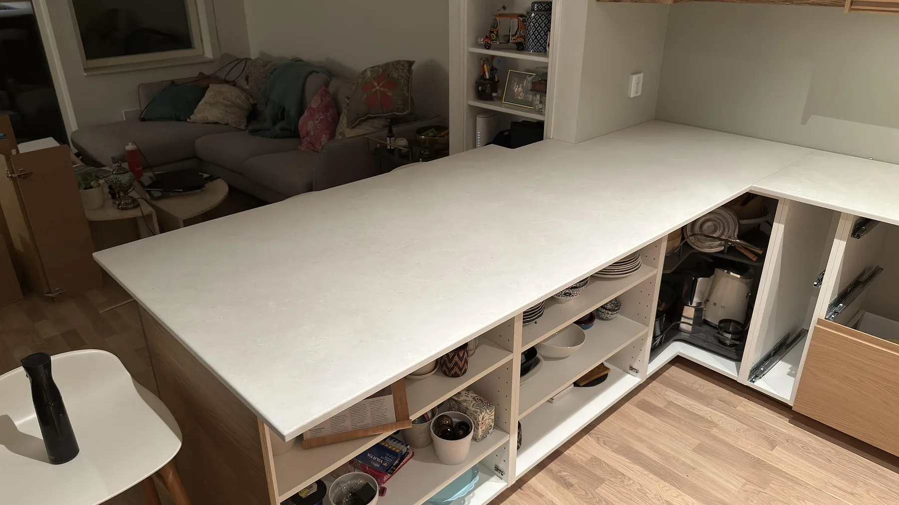 Köksbänk i ljus sandfärgad Dekton Sandik med öppna lådstommar under montering, Saltsjö-Boo.