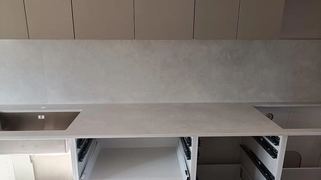 Matt Dekton Sandik köksbänkskiva med sammanhängande arbetsyta, diskzon och stänkskydd över öppna köksstommar i Vellinge.