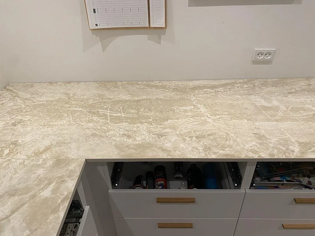 Köksbänkskiva i matt Dekton Sarey i Jyderup ovanifrån med mjuk guldaktig ådring i den ljusa stenen.