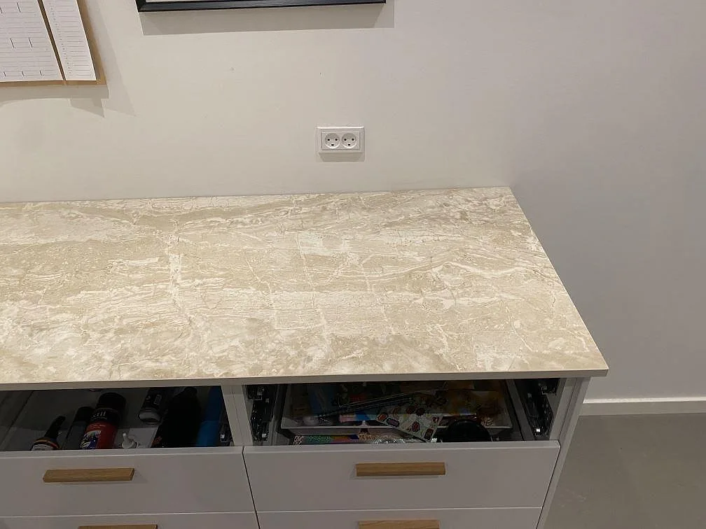 Ovanifrån på en köksbänkskiva i matt Dekton Sarey i Jyderup med levande ljus ådring, fotograferad under montering.
