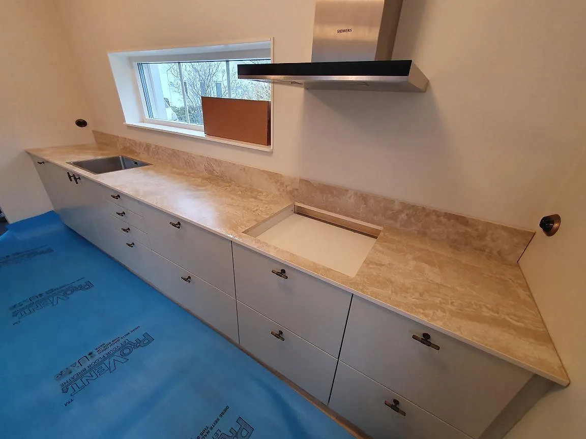 Närbild på matt Dekton Sarey som köksbänkskiva med hällöppning, stänkkant och ljus ådring i Segeltorp.