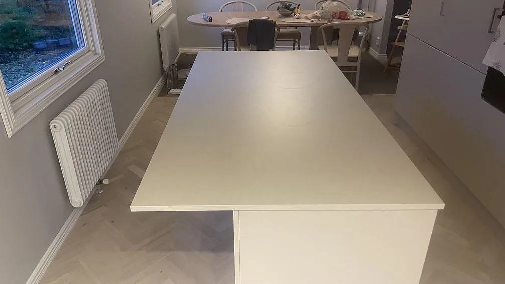 Matt köksbänkskiva i Dekton Sasea, keramik, som stor köksö i ett kök under montering i Åkarp.