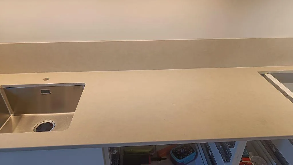 Matt köksbänkskiva i Dekton Sasea med diskho till vänster, hällurtag till höger och låg stänkkant i Malmö.