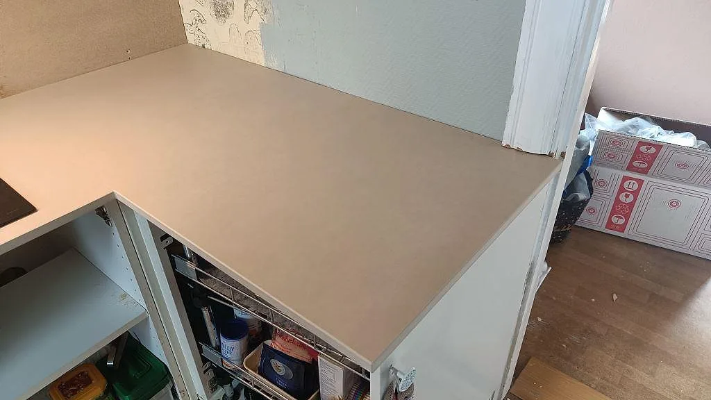 Längre arbetsyta i matt Dekton Sasea, keramik, runt kökshörn med vita stommar i Malmö.