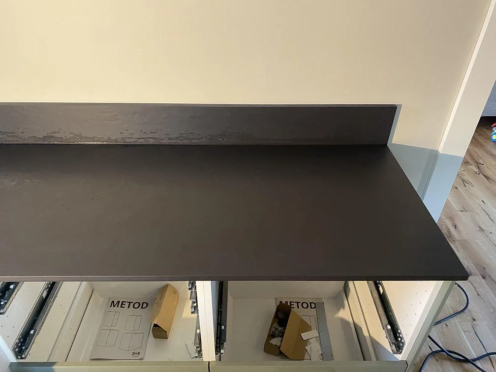 Detalj av underlimmad rostfri diskho i mörk matt Dekton Sirius köksbänkskiva i Ängelholm.
