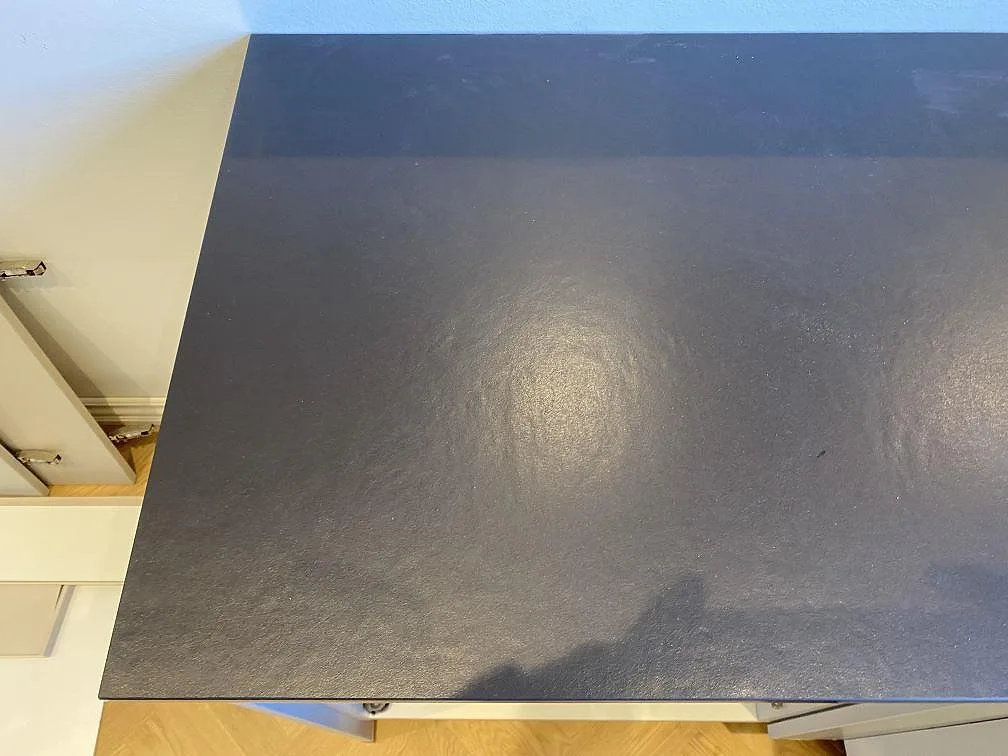 Ytnära bild av matt Dekton Sirius i ett kök, där den mörka keramiska bänkskivan visar sin diskreta struktur i Brønshøj.