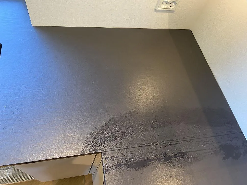 Närbild på hörnet av en köksbänkskiva i matt Dekton Sirius, med mörk keramisk yta vid diskplatsen i Brønshøj.