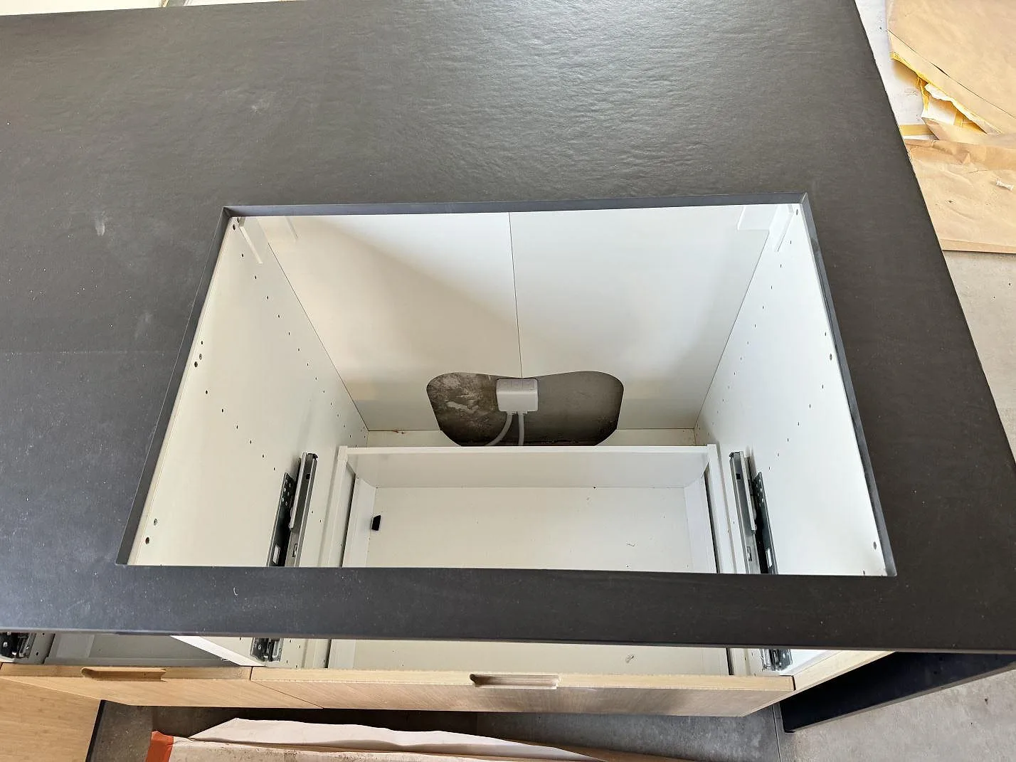 Detalj av hällöppning i matt Dekton Sirius köksbänkskiva med ljusa köksstommar under montering i Höganäs.
