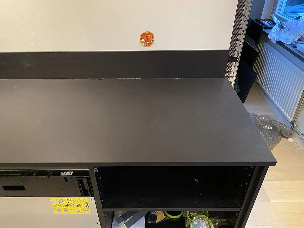 Mörk matt Dekton Sirius bänkskiva med stänkkant vid fönstret i ett kök i Oxie, under pågående montering.