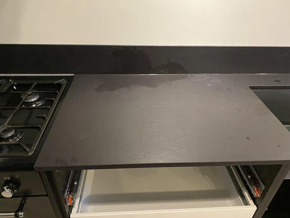Köksbänk i matt Dekton Sirius keramik bredvid en fristående gashäll i ett kök i Oxie.