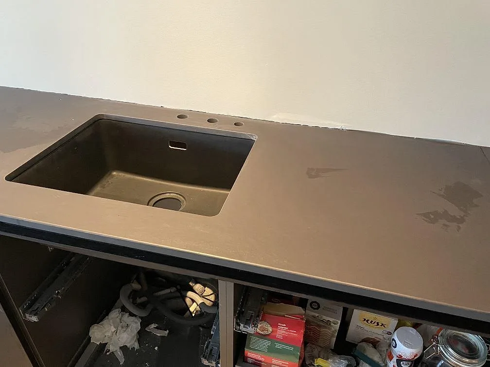 Bänkrad i Dekton Sirius med underlimmad diskho och tre hål för blandare, matt mörk keramikbänkskiva i ett kök i Särö.