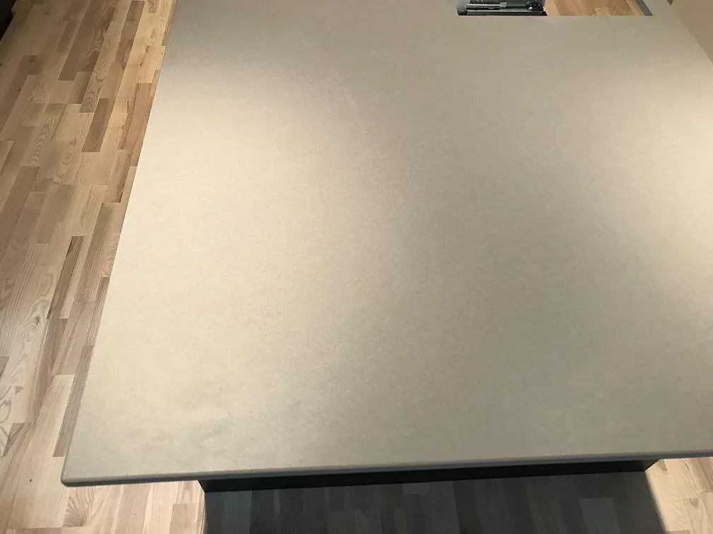 Köksbänkskiva i Dekton Sirocco keramik med vägguttag ovanför, matt beige yta i ett kök i Tygelsjö.