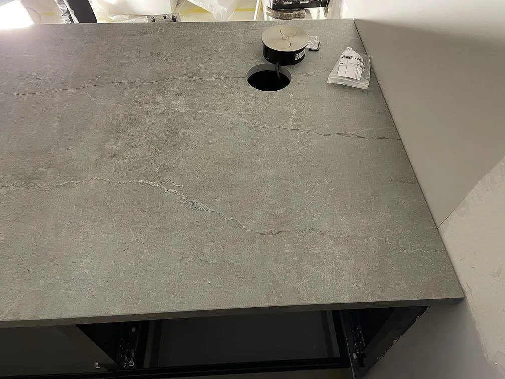 Köksö i grå Dekton Soke sedd uppifrån, matt betonglook med kontakthål och inbyggt eluttag i Arrie.