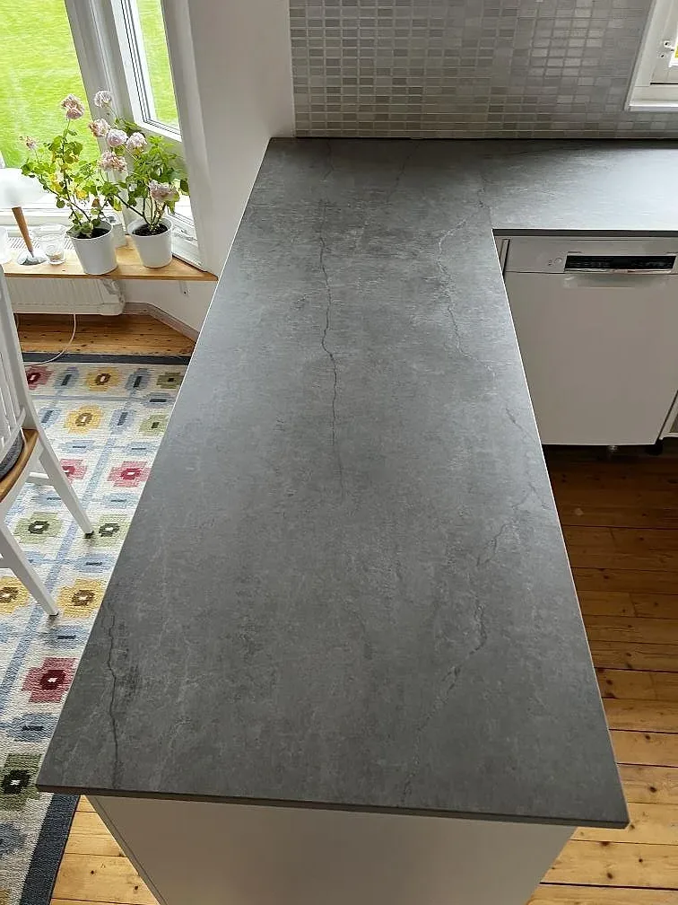 Närbild på den breda arbetsytan i matt Dekton Soke keramik med betonglik ådring i kök i Kyrkesund.