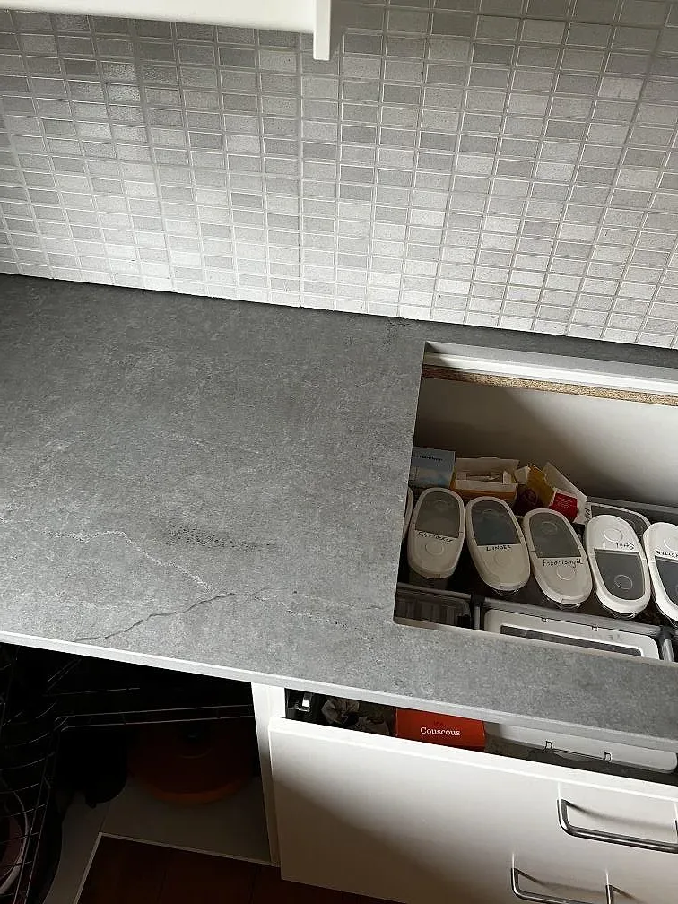 Matt Dekton Soke köksbänkskiva med förberedd hällöppning och vita köksstommar under montering i Kyrkesund.