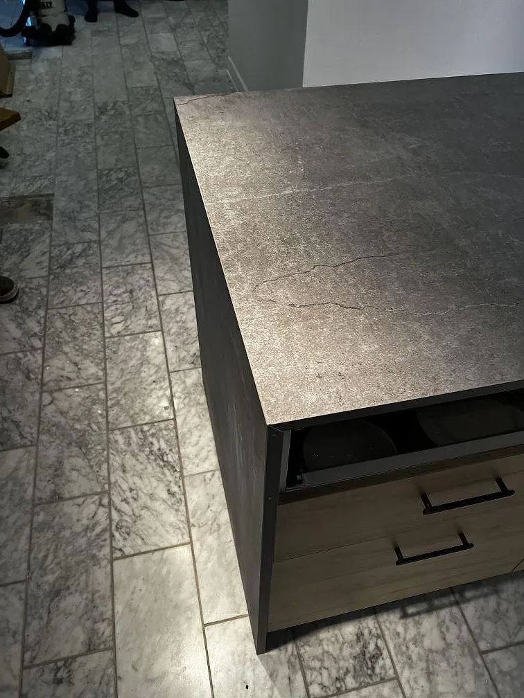 Detalj av vattenfallssida och bänkskiva i Dekton Soke, matt grå keramik, på köksö i Löddeköpinge.