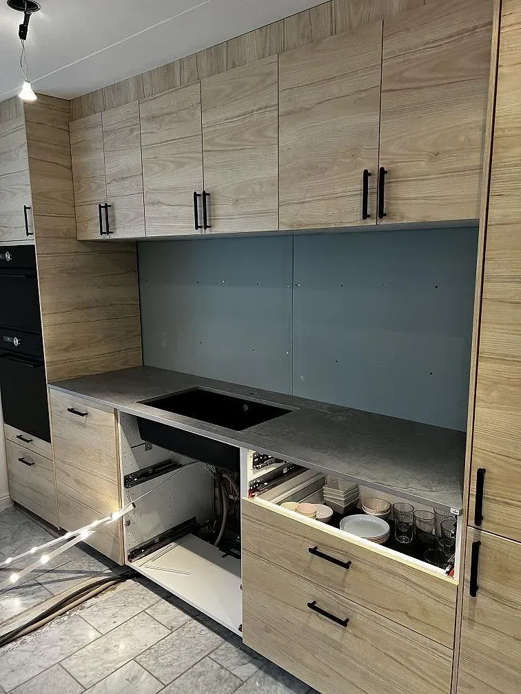 Köksbänkskiva i grå Dekton Soke, matt keramik, med svart övermonterad diskho och träinredning i Löddeköpinge.