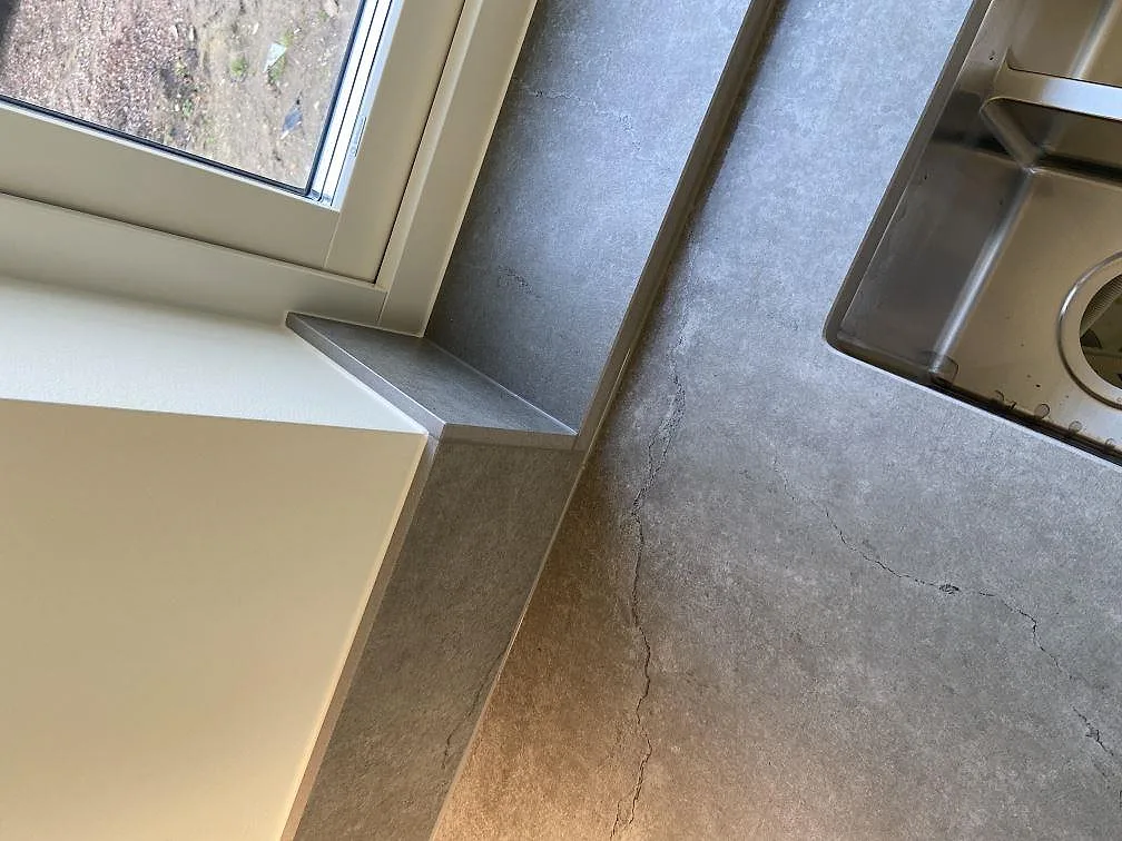 Greige Dekton Soke bänkskiva sedd ovanifrån över en köksstomme i ett kök i Vintrie.