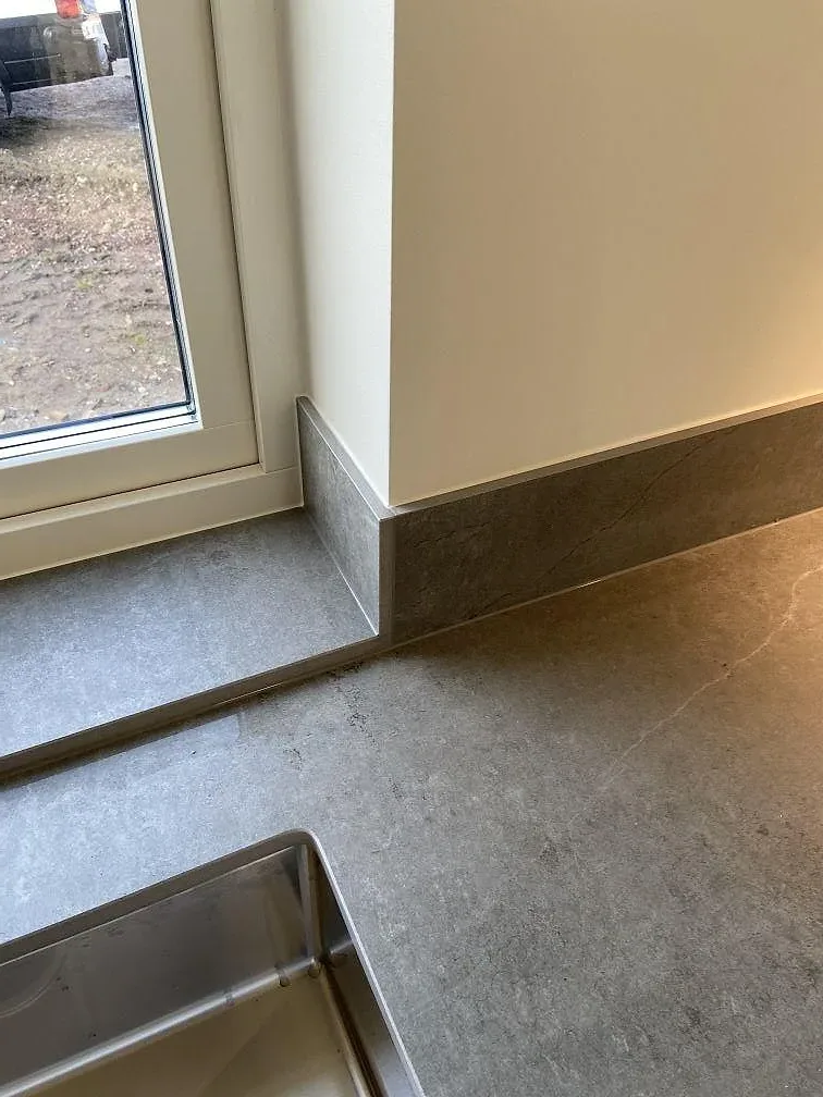 Matt Dekton Soke bänkskiva och stänkskydd kring ett eluttag i ett kök i Vintrie.