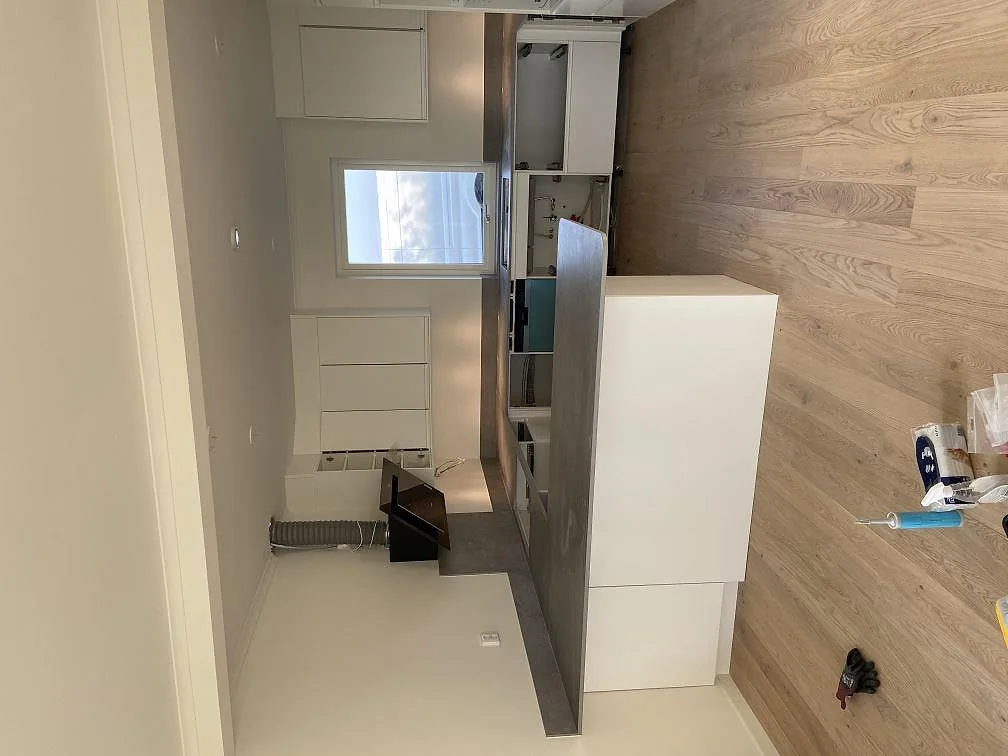 Närbild på matt greige Dekton Soke bänkskiva med stänkskydd i ett kök i Vintrie.