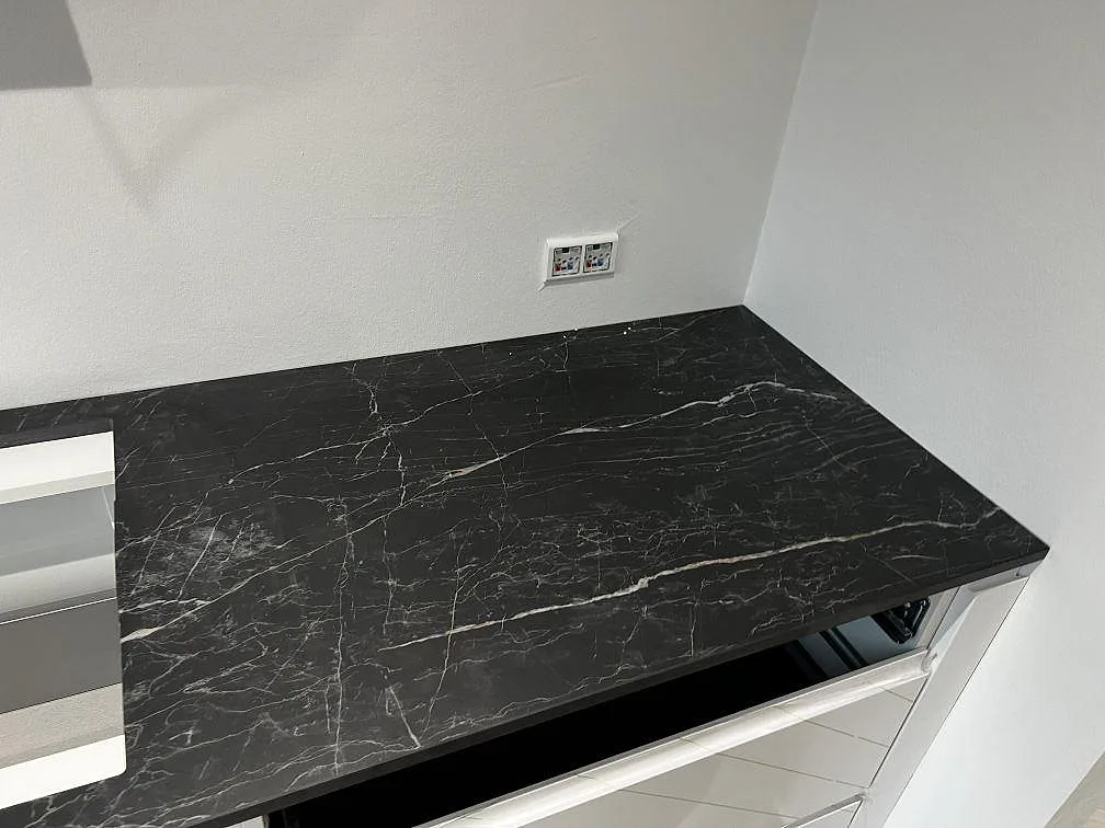 Närbild på mörk polerad Dekton Somnia bänkskiva i keramik med markerad ådring och hällurtagning i Ballerup.