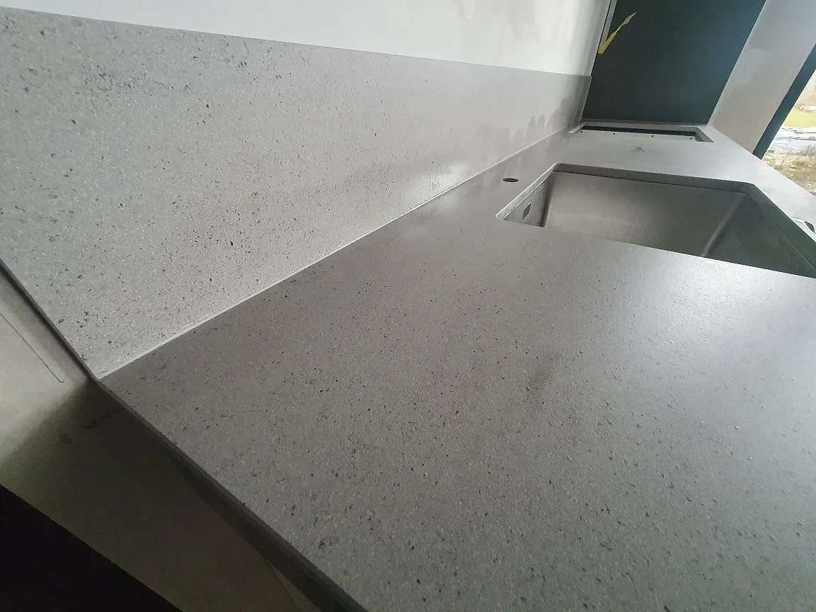 Närbild på den matta ytan och den fina gråspräckliga strukturen i Dekton Strato köksbänkskiva i Svärdsklova Nyköping.