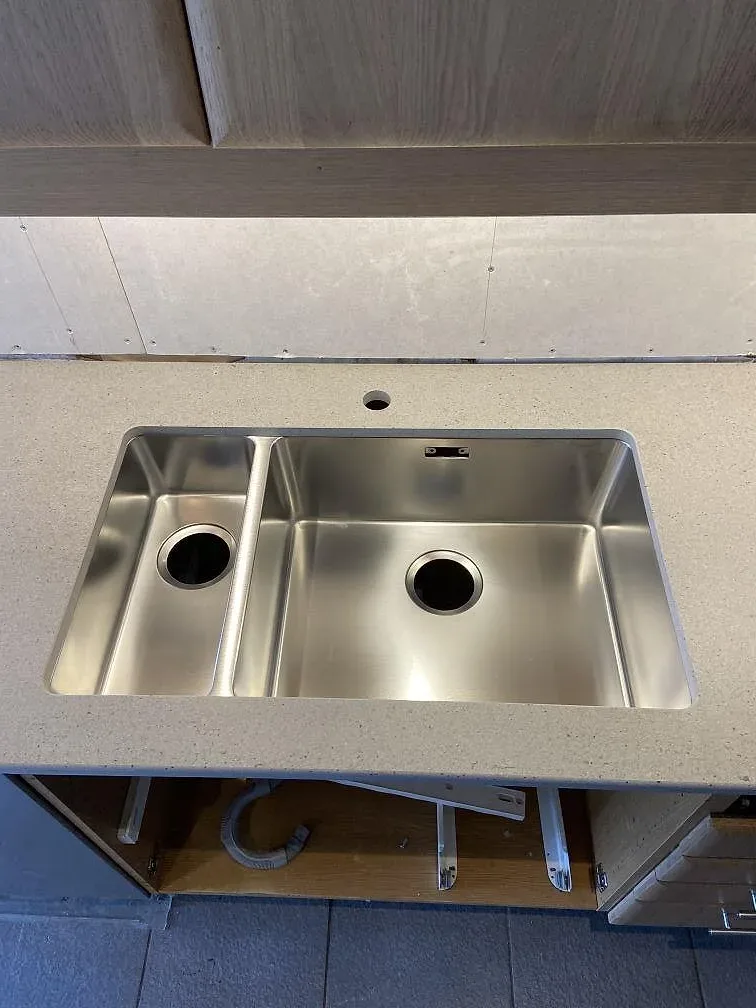 Närbild på matt Dekton Strato med rostfri diskho i ett kök under färdigställning i Trelleborg.