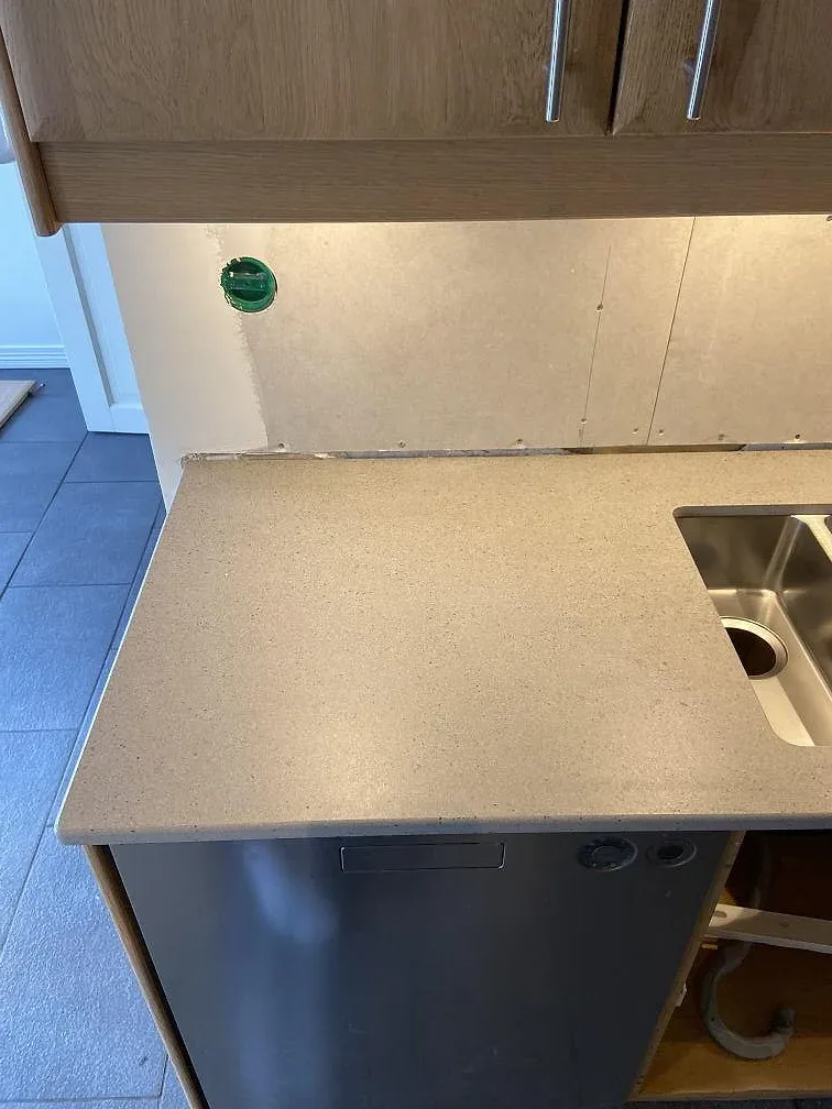 Sidovy av matt Dekton Strato vid diskho och öppna köksskåp i Trelleborg.