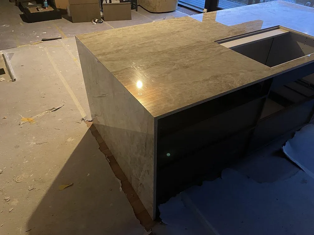 Köksö i Dekton Taga 20mm polerad med matchande nedfälld sida, beige keramikbänkskiva i ett kök under inredning i Gentofte.