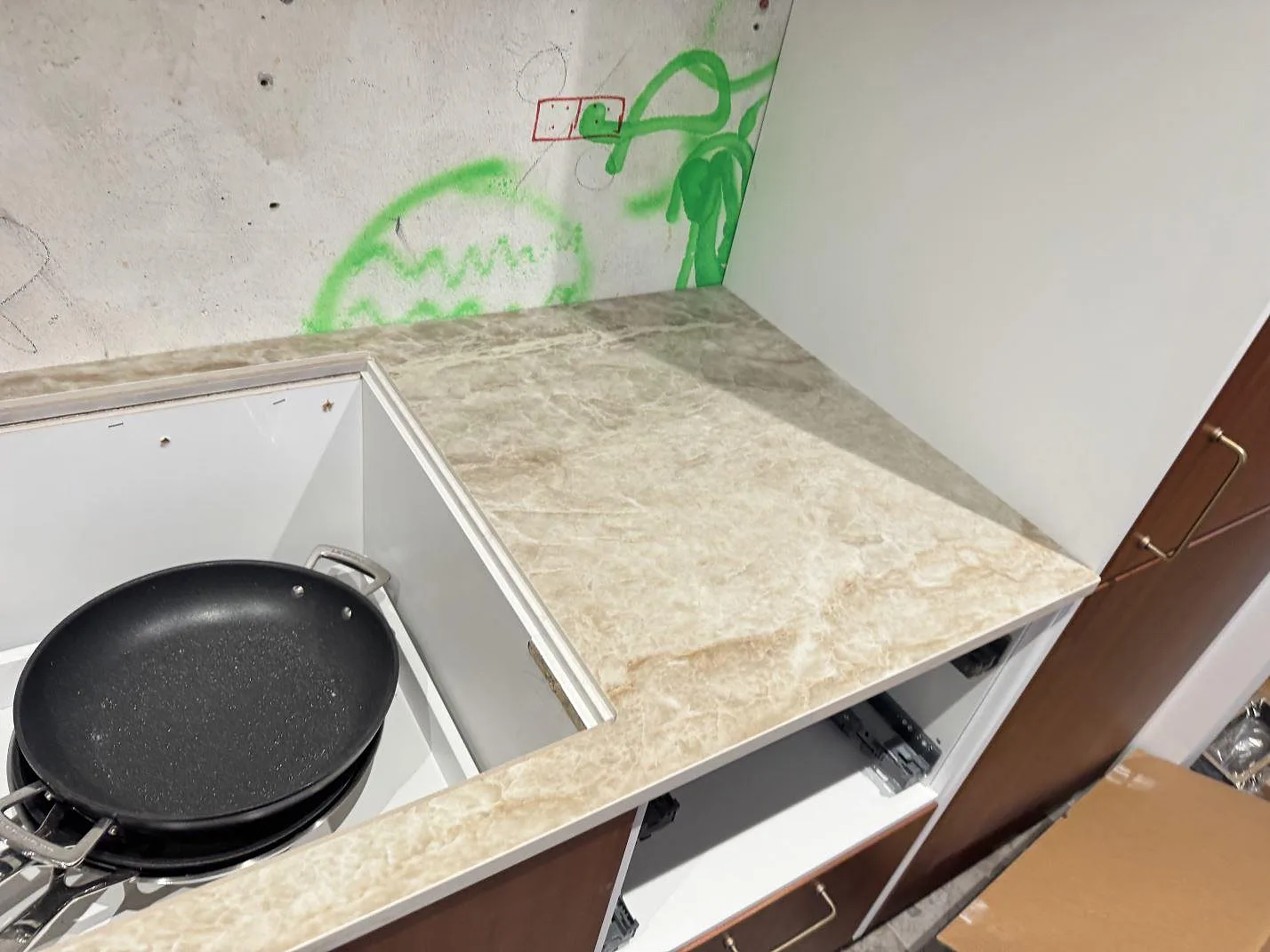 Dekton Taga som polerad keramikbänkskiva runt ett större köksurtag med brun träinredning i Glostrup.