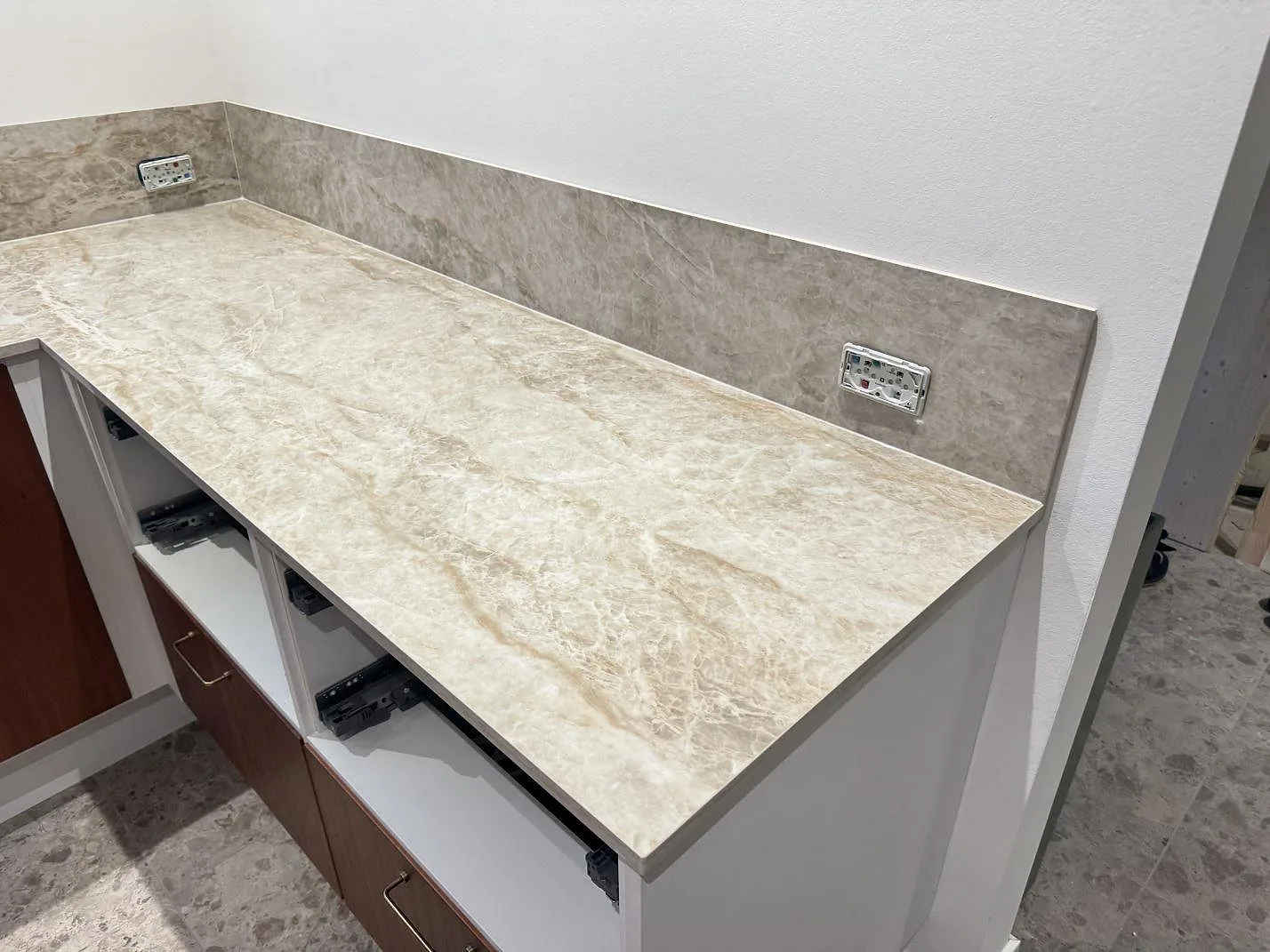 Rak köksbänkskiva i polerad Dekton Taga med vägguttag i stänkskyddet och öppna stommar i Glostrup.