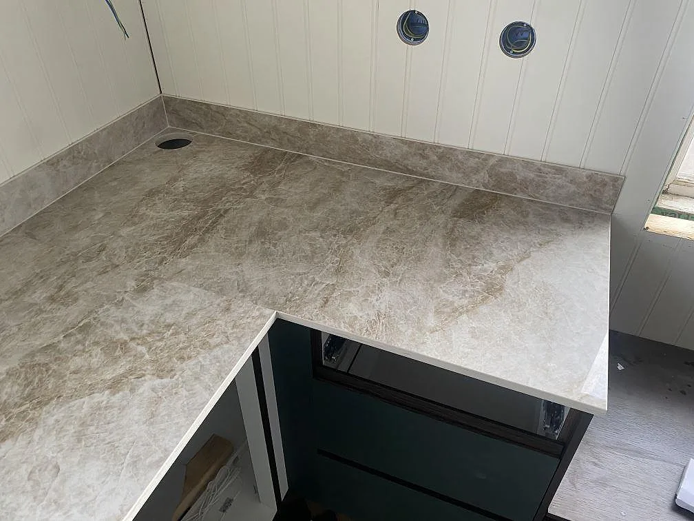 Underlimmad rostfri dubbeldiskho i en köksbänkskiva i Dekton Taga med ådrig keramikyta i Göteborg.
